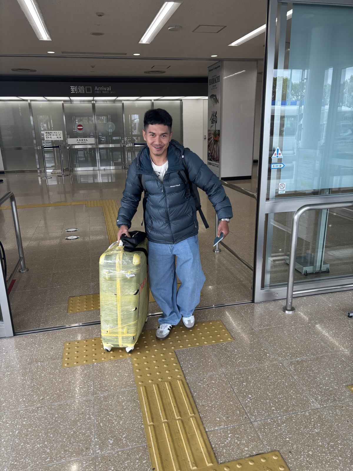 到着口で荷物を持つスタッフ